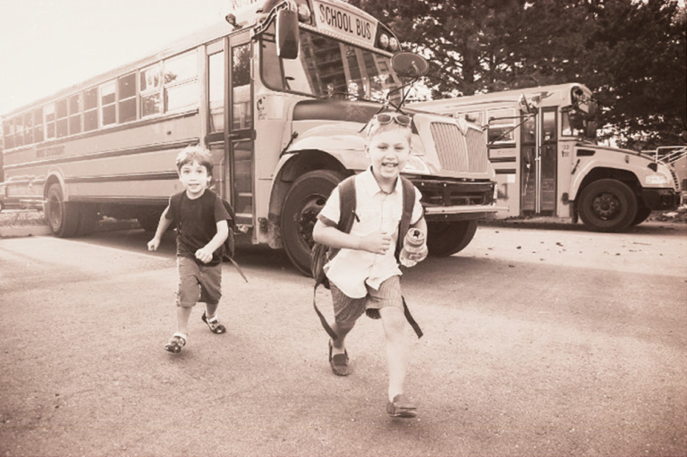 Old Timey filtered picture with two kids running out of a bus